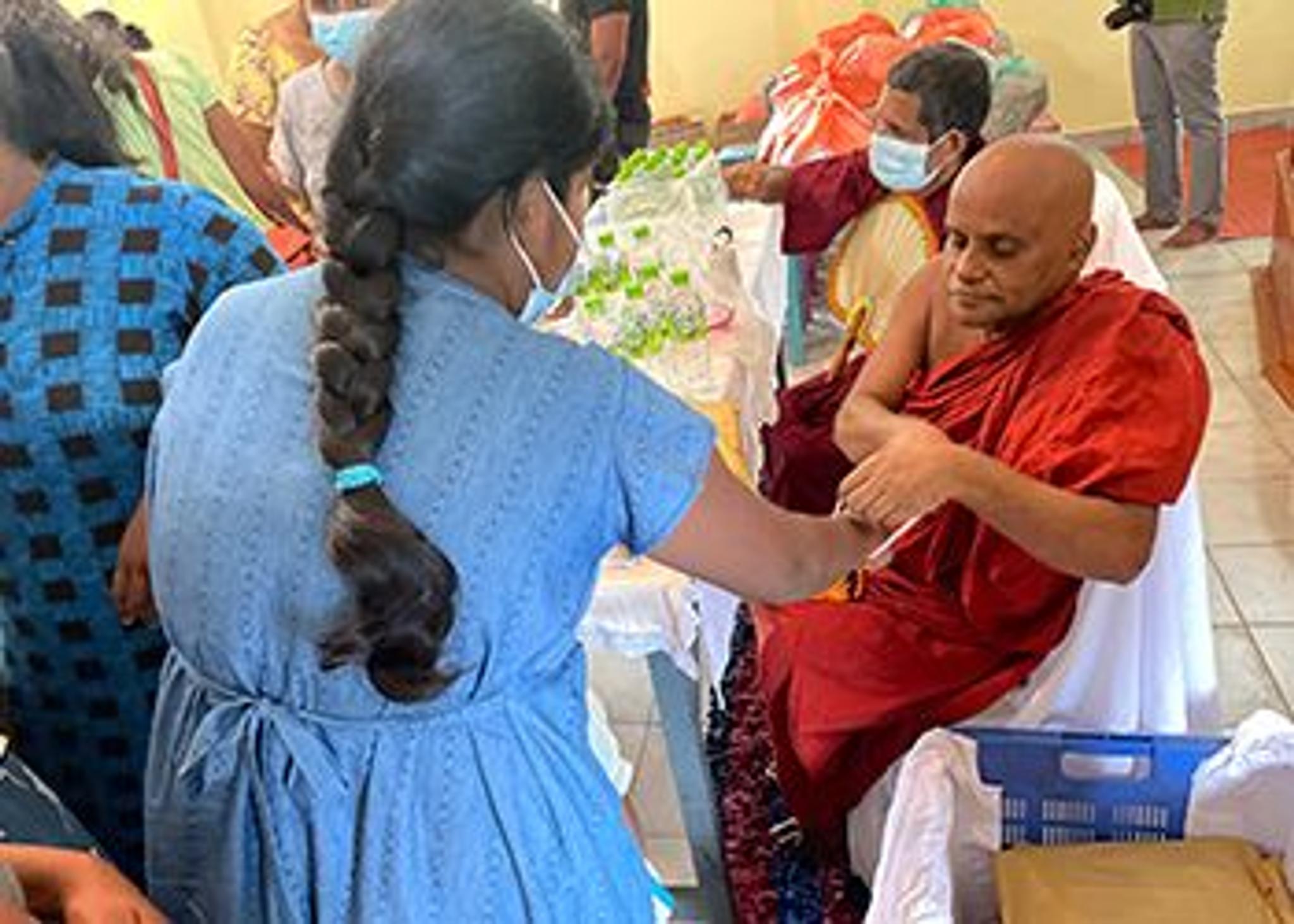 A buddhist monk blessing a pregnant woman