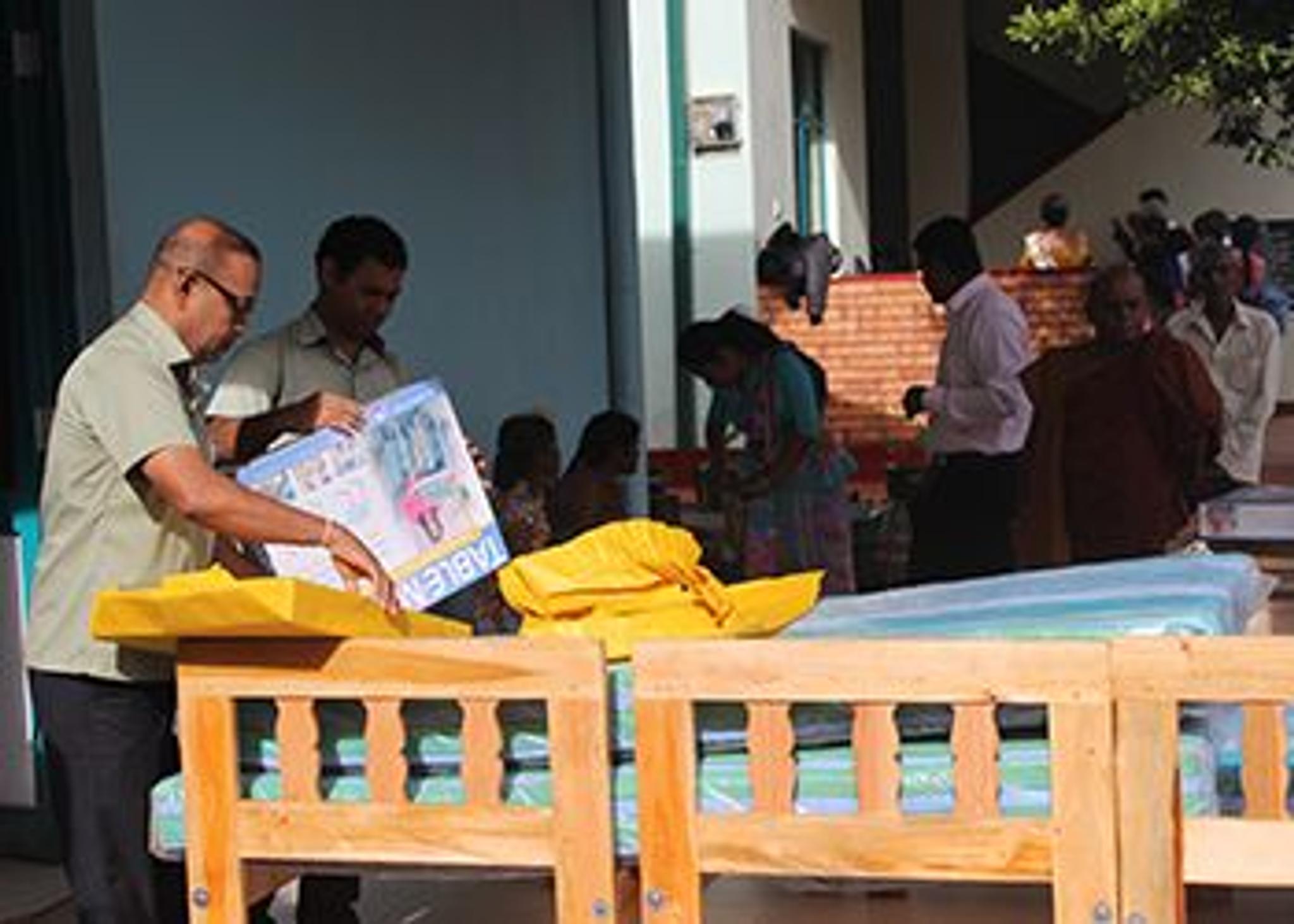 People arranging wooden beds for hospital donation