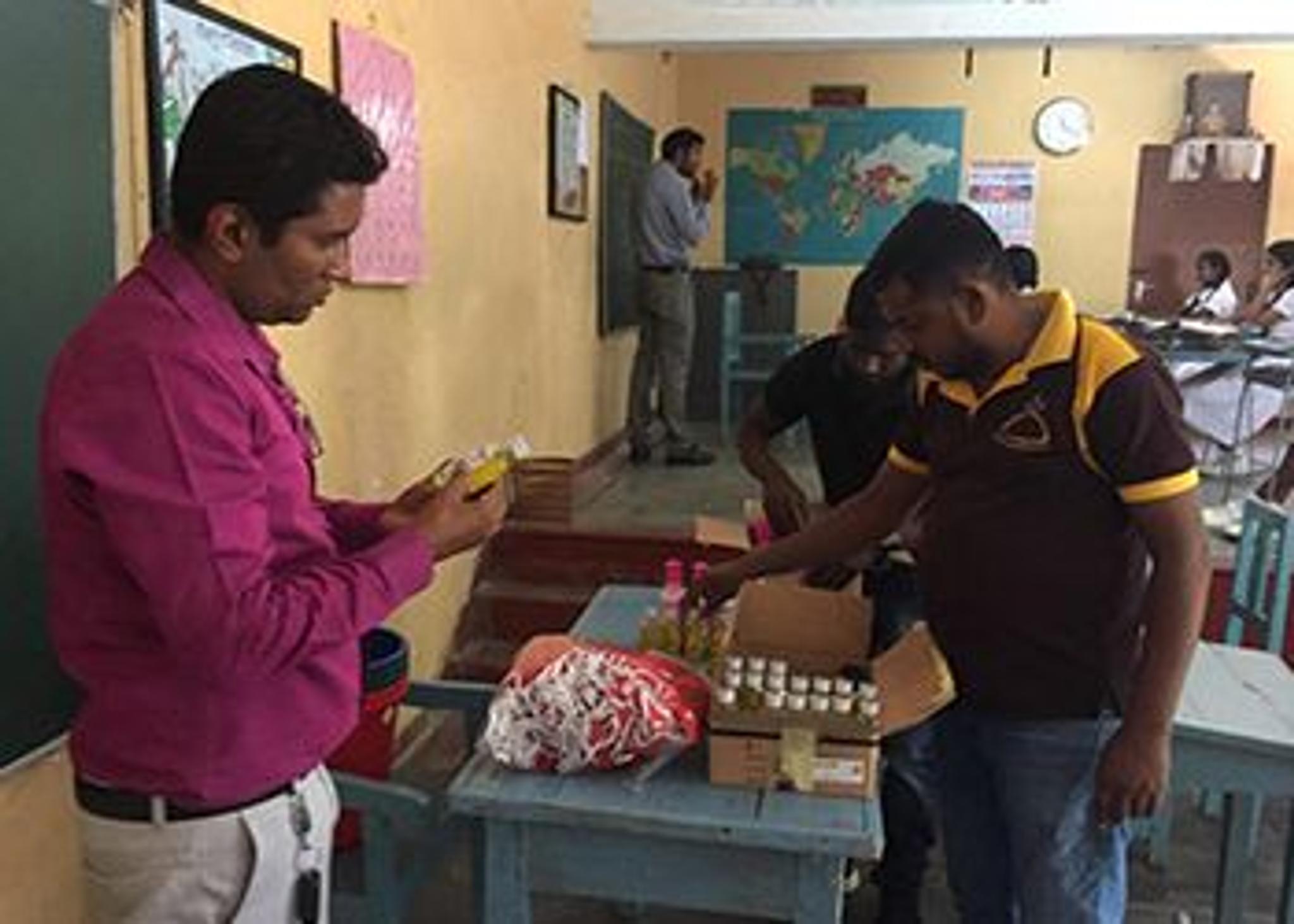 People preparing supplies inside a school classroom