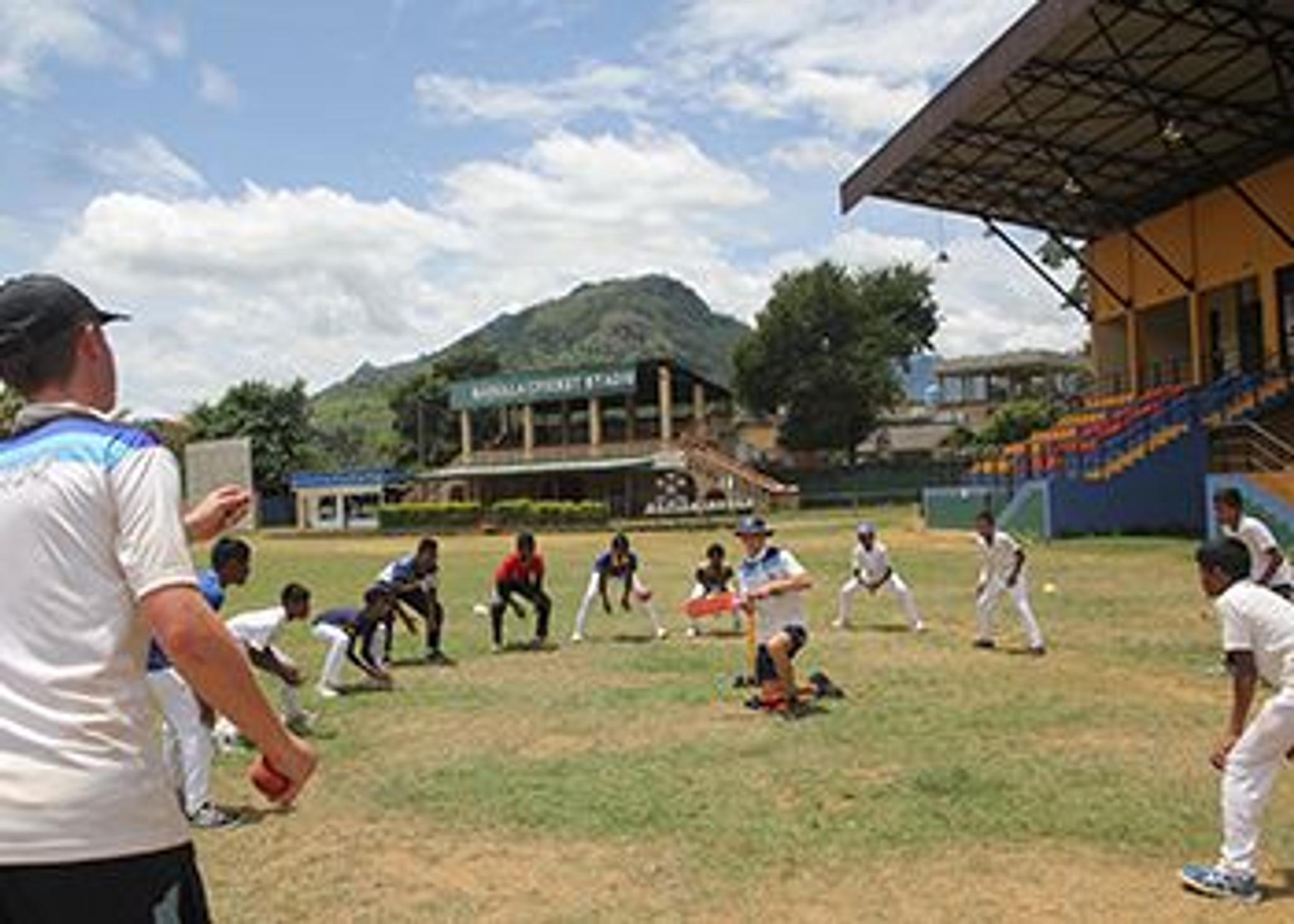 Young school cricketers training on a field